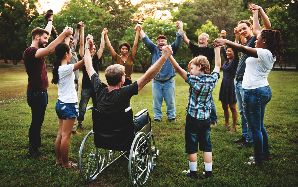 a photo of a group of people raising their hands together in a circle